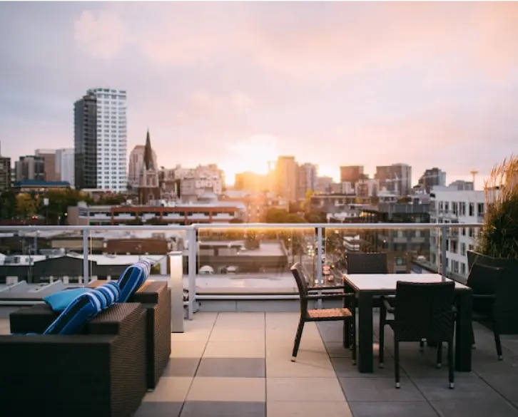 un patio avec des tables et des chaises et l'horizon de la ville en arrière-plan